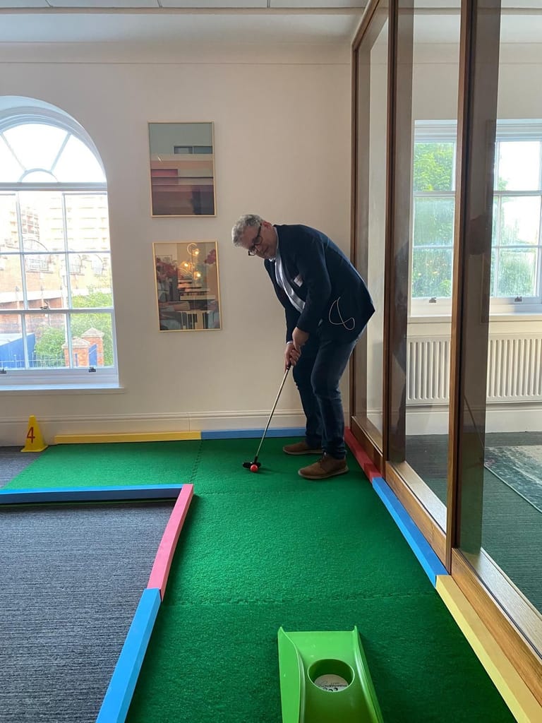 A delegate playing mini golf at a UKREiiF fringe event